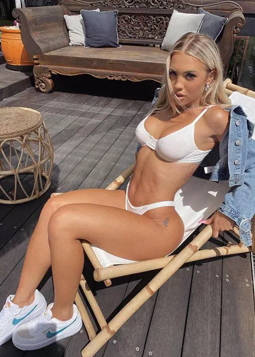 Young blonde woman poses in a white bikini.