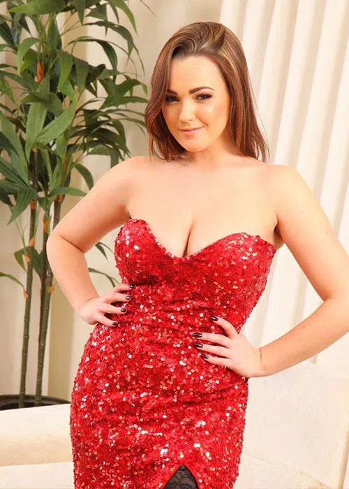 Murielle smirks as she shows off in glittery red dress.
